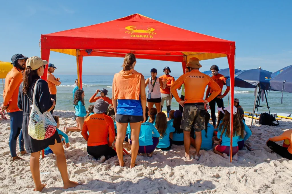 Turma do Surf Camp reunida com os instrutores na praia