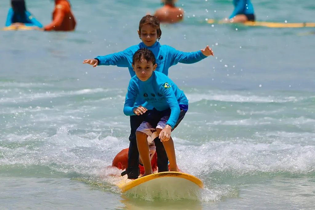 Dois alunos do Surf Camp dividindo a mesma onda