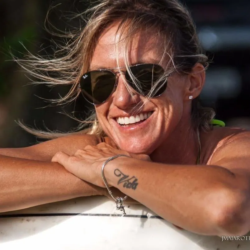 Andrea Lopes sorrindo, apoiada na prancha